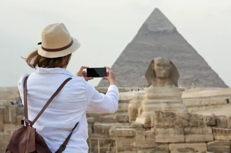 Una Donna Che scatta un foto alle piramidi, vacanze pasqua egitto